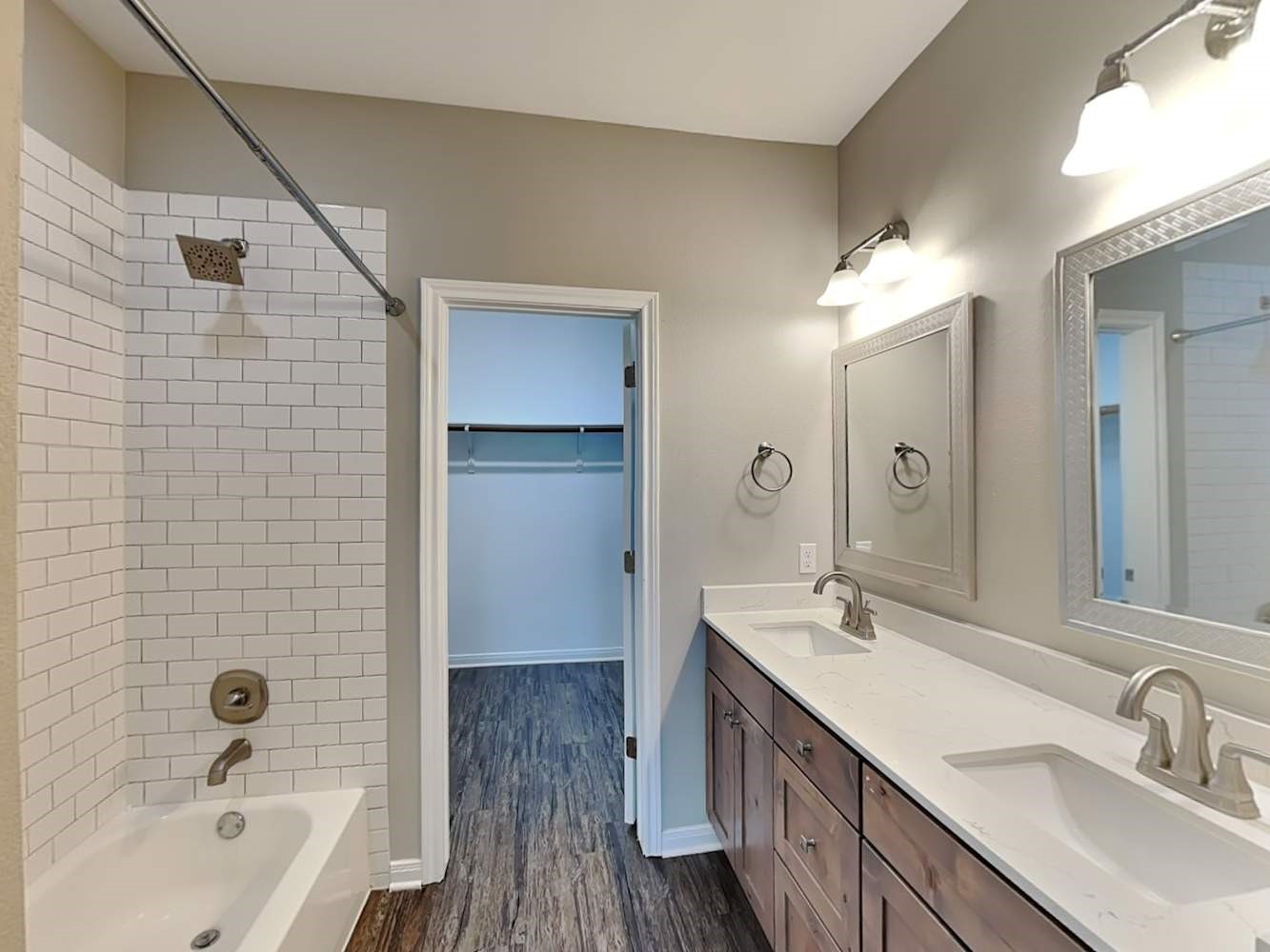 179 Holly Street, Unit 503 Georgetown, TX 78626 - Photo 8 of 18 a bathroom with a double vanity sink a mirror and a bathtub