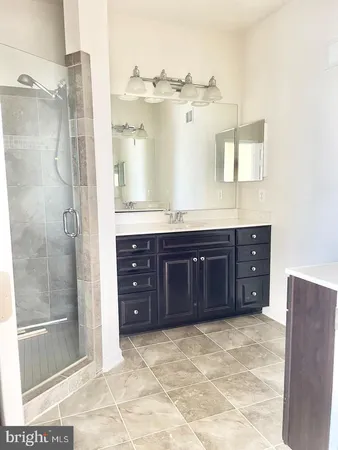 a bathroom with a granite countertop sink mirror and shower