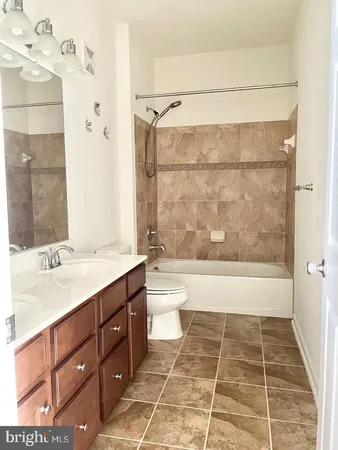 a bathroom with a double vanity sink toilet and shower