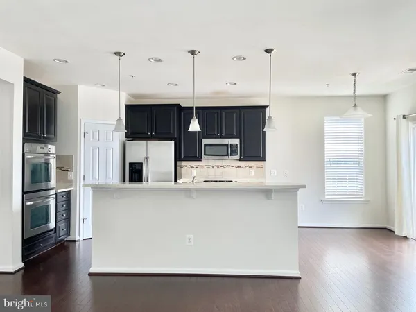 a view of kitchen with stainless steel appliances granite countertop a refrigerator a stove a sink and a microwave
