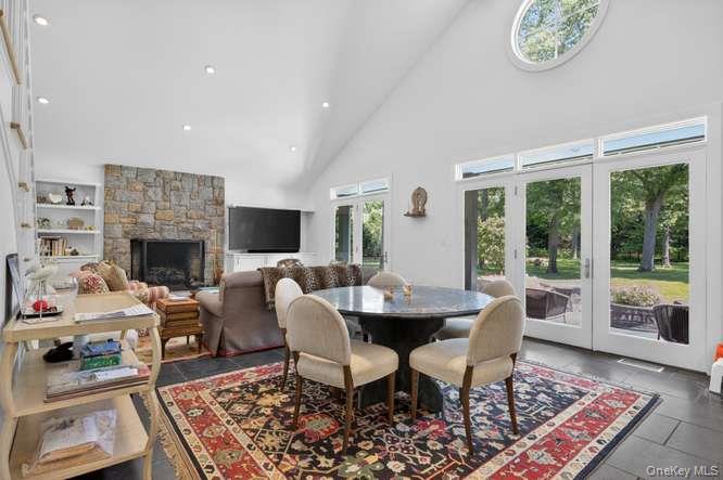 343 Chicken Valley Road Glen Head, NY 11545 - Photo 17 of 49 a dining room with furniture a rug a fireplace and a window