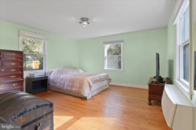 a bedroom with a bed and a flat tv screen on dresser
