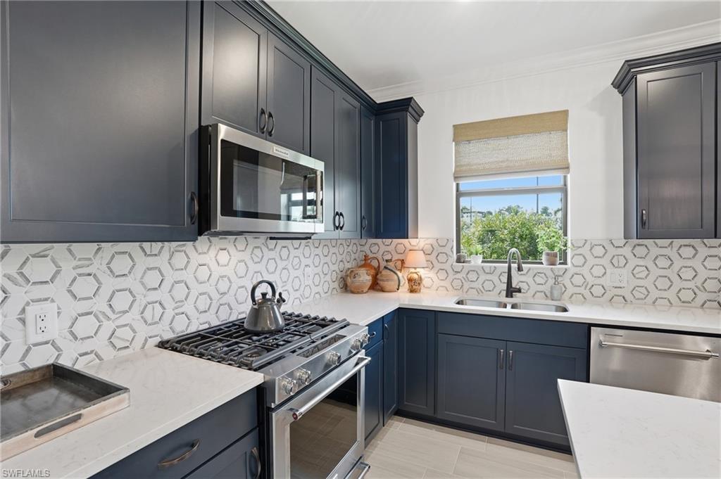 1955 Sierra Court Naples, FL 34120 - Photo 11 of 50 a kitchen with stainless steel appliances a sink stove and microwave