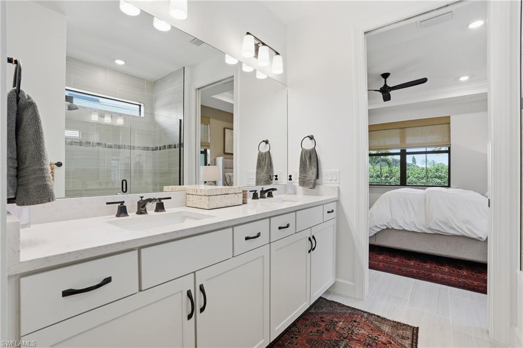1955 Sierra Court Naples, FL 34120 - Photo 19 of 50 a en suite bathroom with a double vanity sink a mirror a and a shower