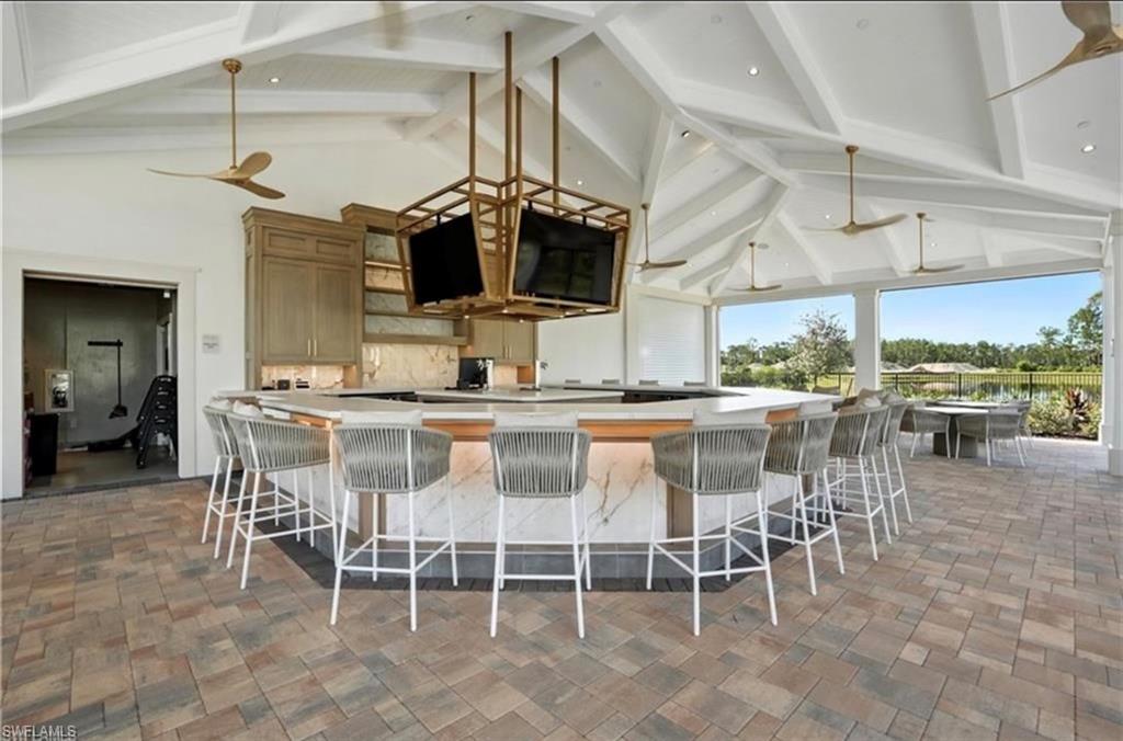 1955 Sierra Court Naples, FL 34120 - Photo 48 of 50 a dining hall with stainless steel appliances kitchen island granite countertop a table and chairs
