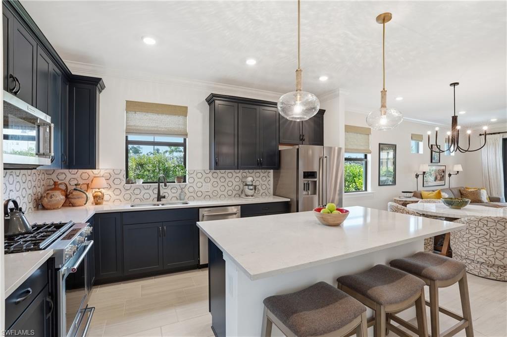 1955 Sierra Court Naples, FL 34120 - Photo 8 of 50 a kitchen with a sink a stove and chairs