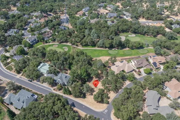 an aerial view of a house with a yard and lake view in back