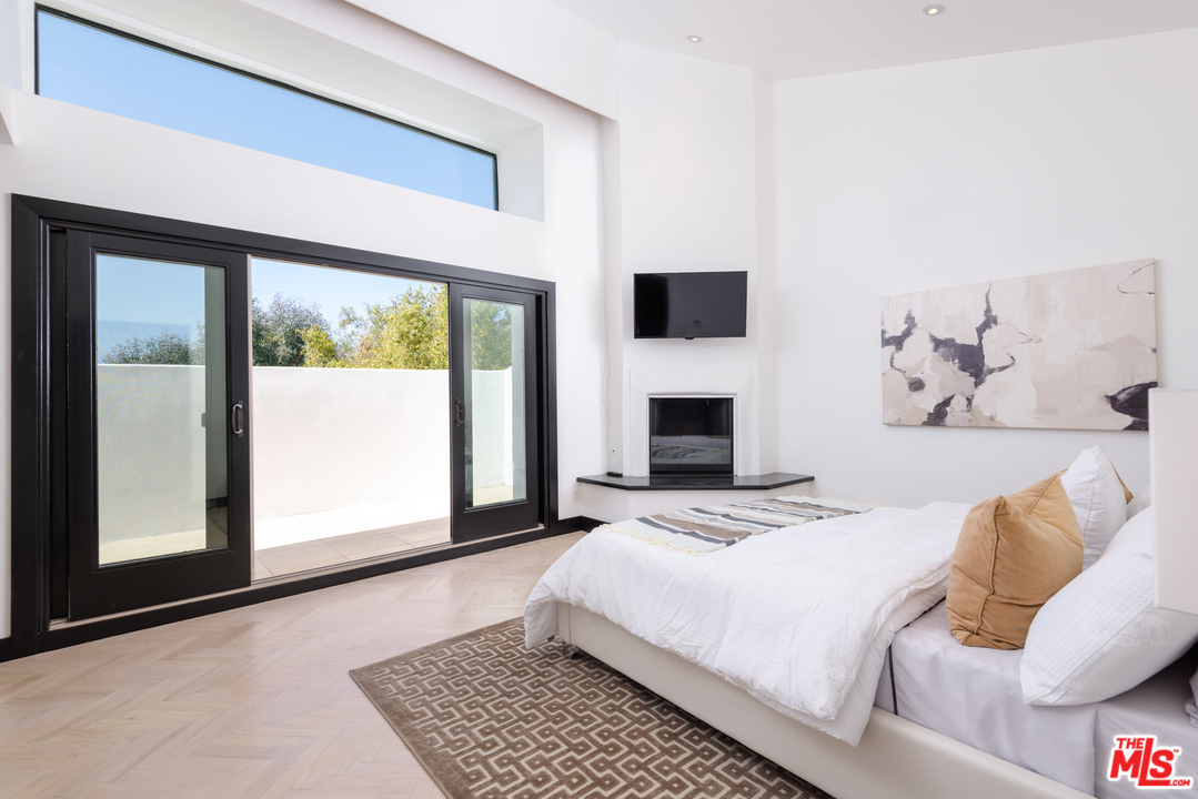 2663 Desmond Estates Road Los Angeles, CA 90046 - Photo 15 of 27 a bedroom with a large bed and a flat screen tv