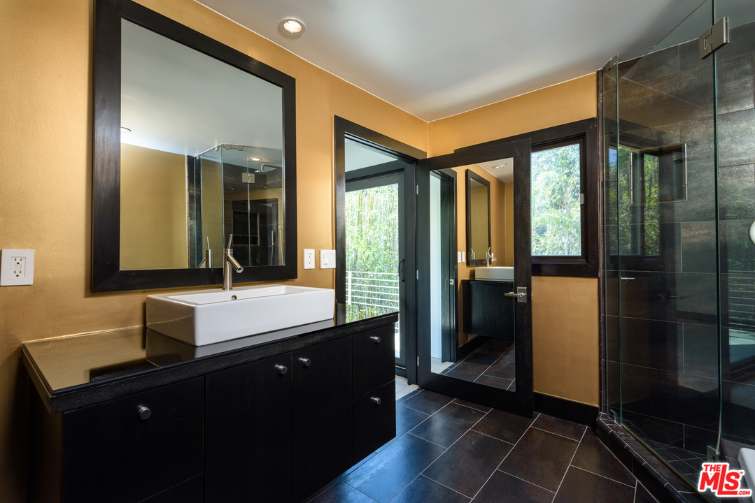 2663 Desmond Estates Road Los Angeles, CA 90046 - Photo 22 of 27 a bathroom with a double vanity sink a mirror and a shower