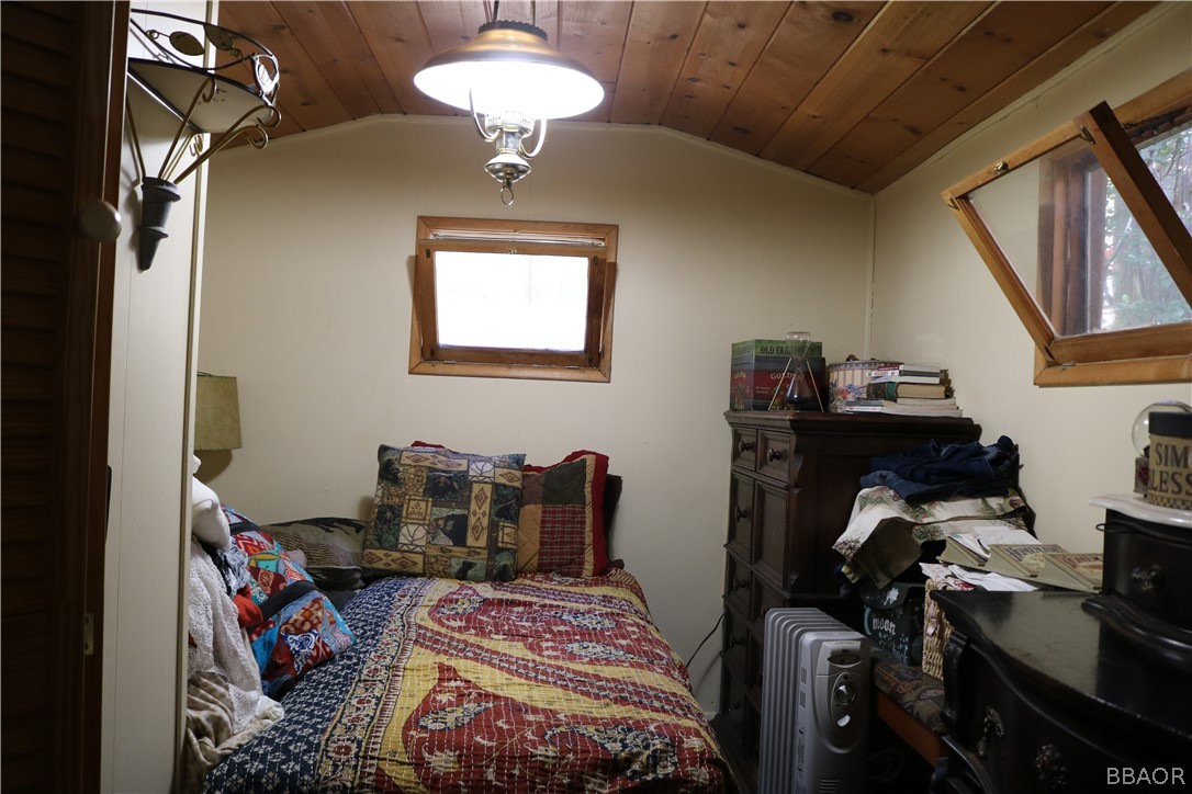 39372 Cedar Dell Road Fawnskin, CA 92333 - Photo 12 of 18 a bedroom with a bed and wooden floor