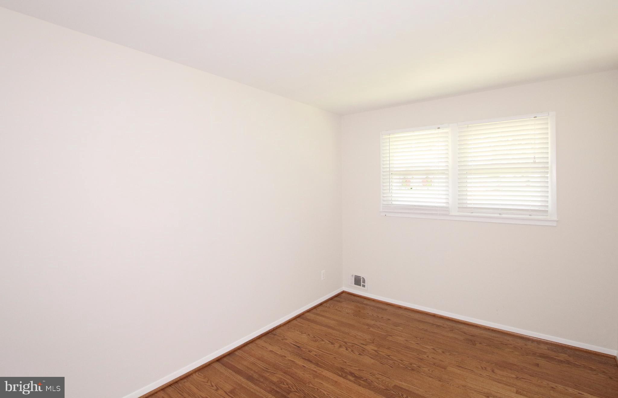 5300 Ravensworth Road Springfield, VA 22151 - Photo 19 of 28 an empty room with wooden floor and windows
