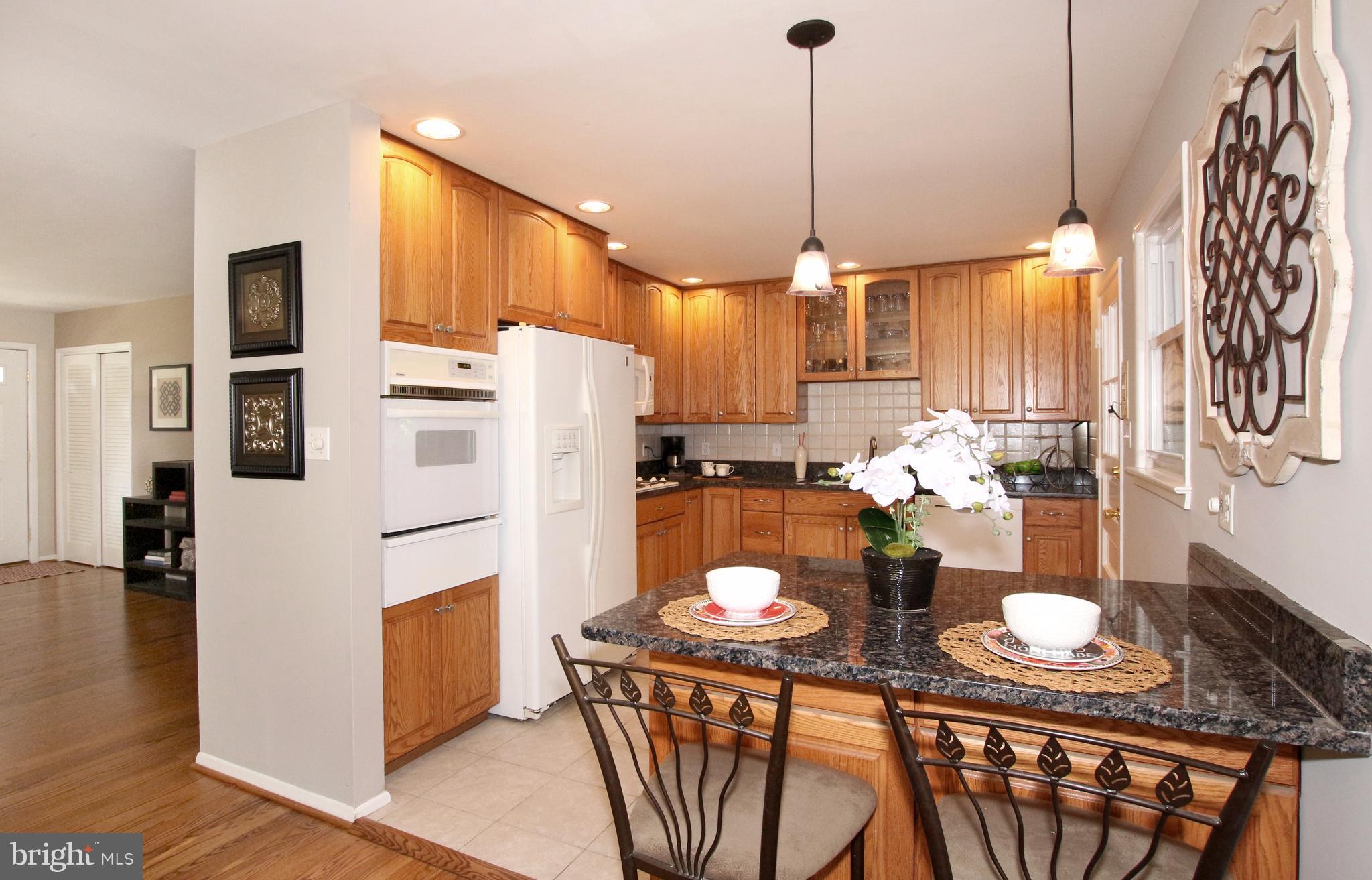 5300 Ravensworth Road Springfield, VA 22151 - Photo 6 of 28 a white kitchen with stainless steel appliances a white table and chairs