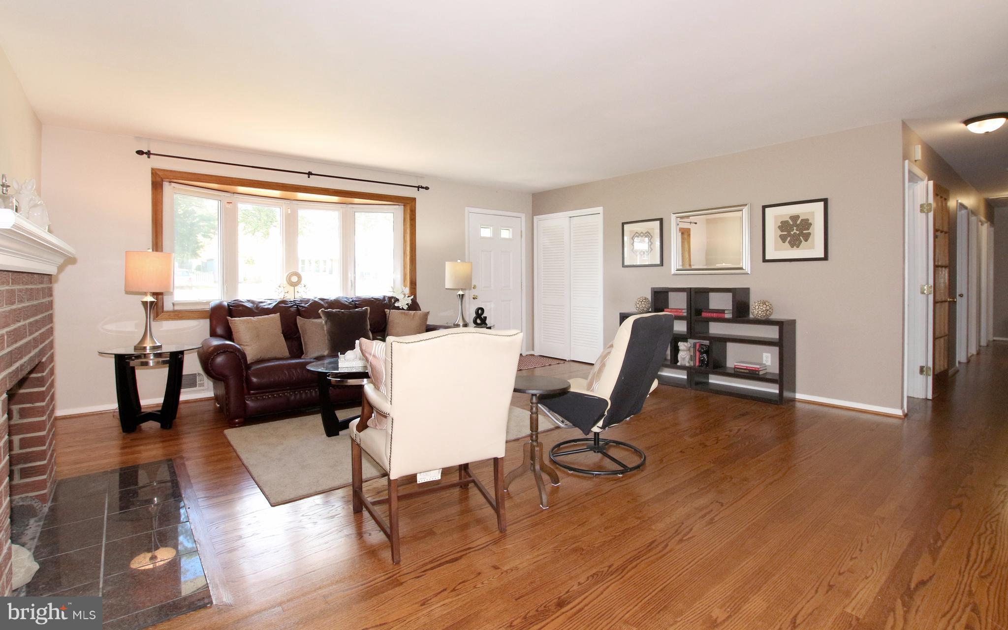 5300 Ravensworth Road Springfield, VA 22151 - Photo 9 of 28 a living room with furniture a large window and a dining table with wooden floor