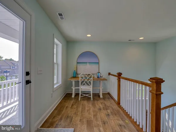 a view of a room with wooden floor furniture and windows