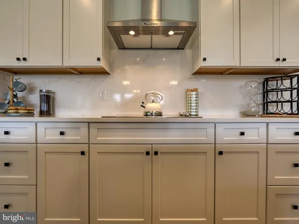 a kitchen with granite countertop white cabinets and a stove