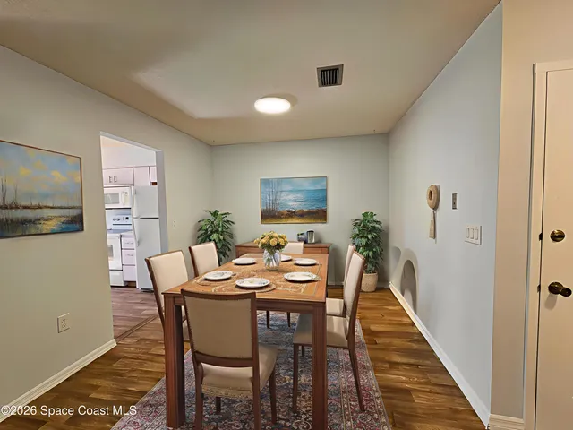 a dining room with furniture and wooden floor