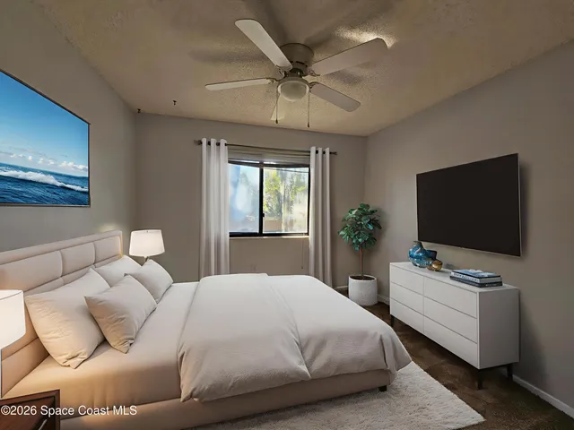 a bedroom with bed tv and window