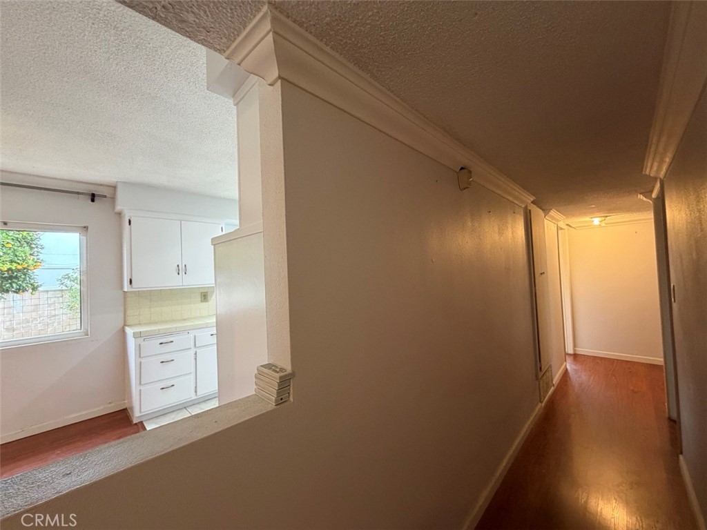 22706 Rashdall Avenue Carson, CA 90745 - Photo 12 of 32 a view of a kitchen with white cabinets and wooden floor