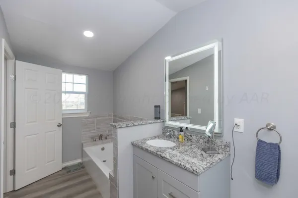 a bathroom with a granite countertop sink and a mirror