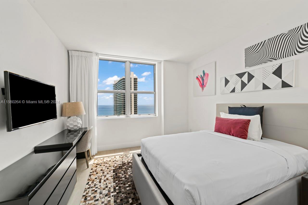 4010 South Ocean Drive, Unit R3001 Hollywood, FL 33019 - Photo 18 of 44 a bedroom with a large bed and a flat screen tv