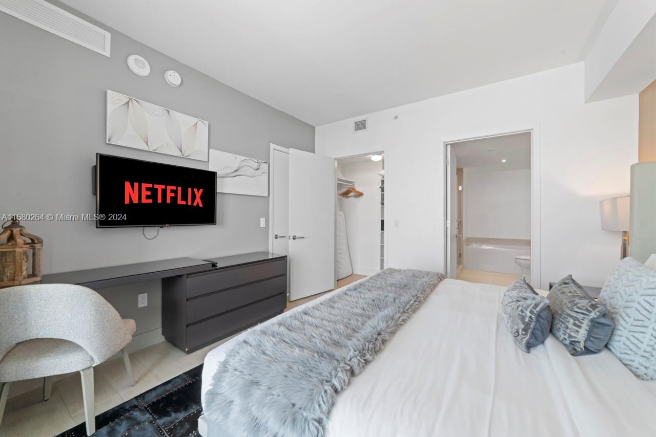 4010 South Ocean Drive, Unit R3001 Hollywood, FL 33019 - Photo 30 of 44 a bedroom with a bed and a flat screen tv