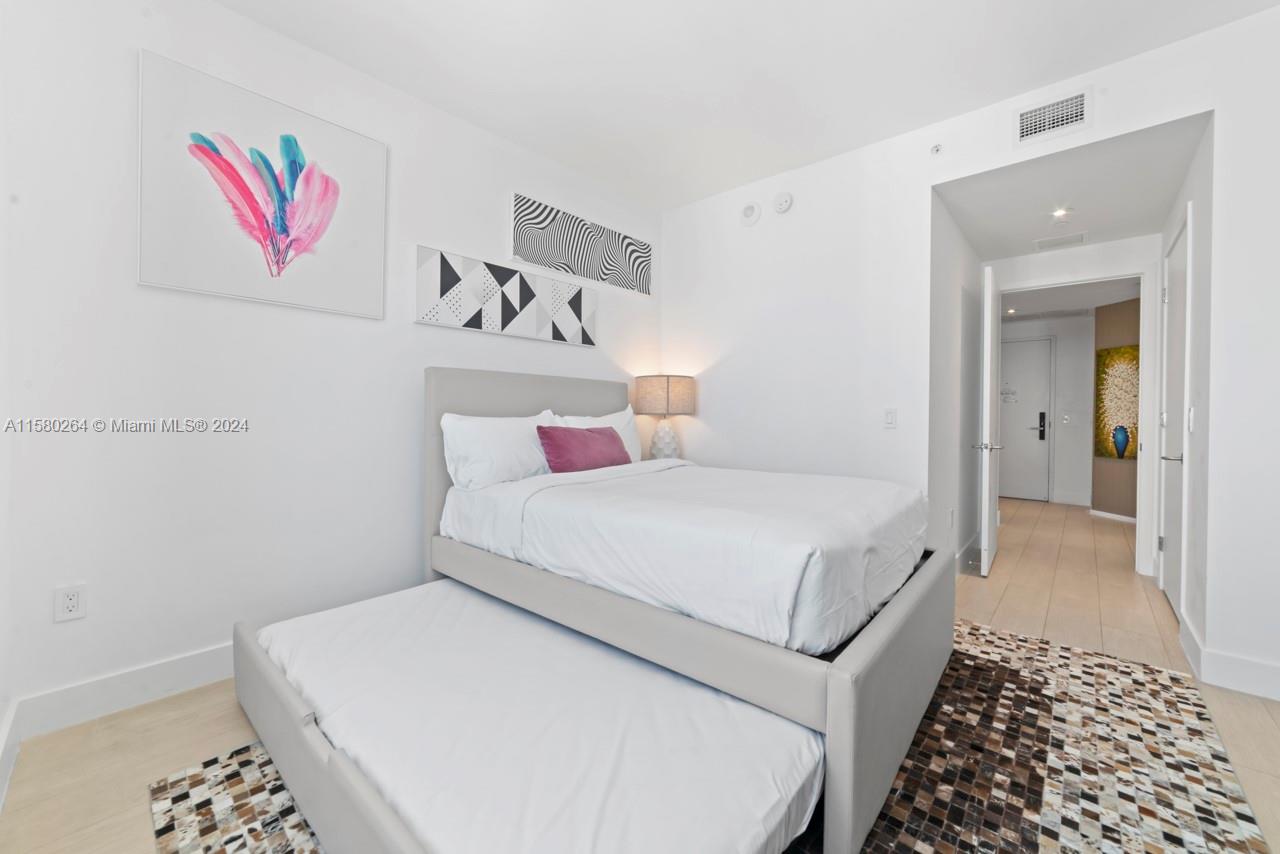 4010 South Ocean Drive, Unit R3001 Hollywood, FL 33019 - Photo 32 of 44 a bedroom with a bed and a cabinets