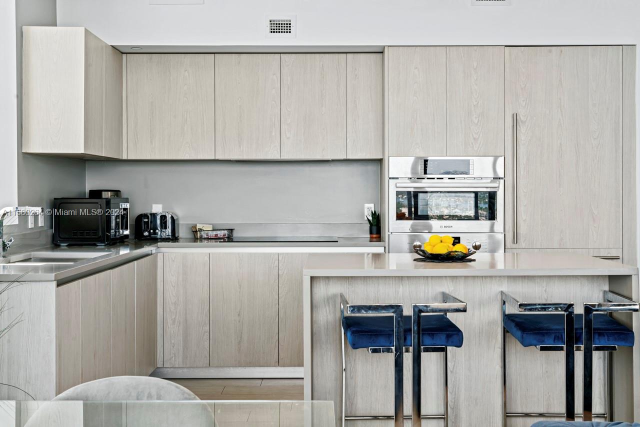 4010 South Ocean Drive, Unit R3001 Hollywood, FL 33019 - Photo 8 of 44 a kitchen with stainless steel appliances a stove a sink and white cabinets