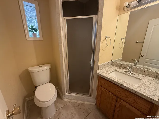 a bathroom with a granite countertop toilet and sink