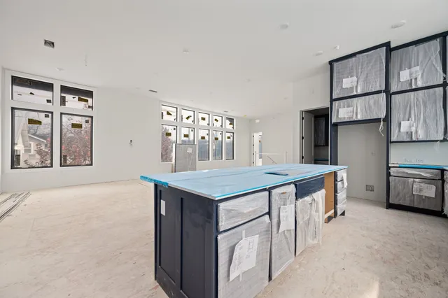 a kitchen with kitchen island a stove a refrigerator a sink dishwasher with a dining table and chairs