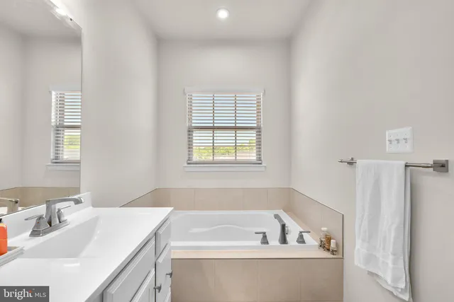 a bathroom with a tub sink and mirror