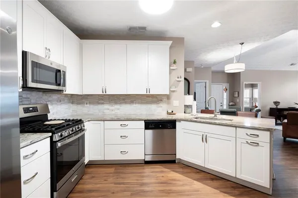 a kitchen with a sink stove and microwave