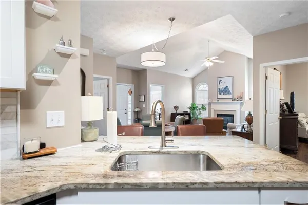 a view of a kitchen counter space a sink wooden floor and living room view