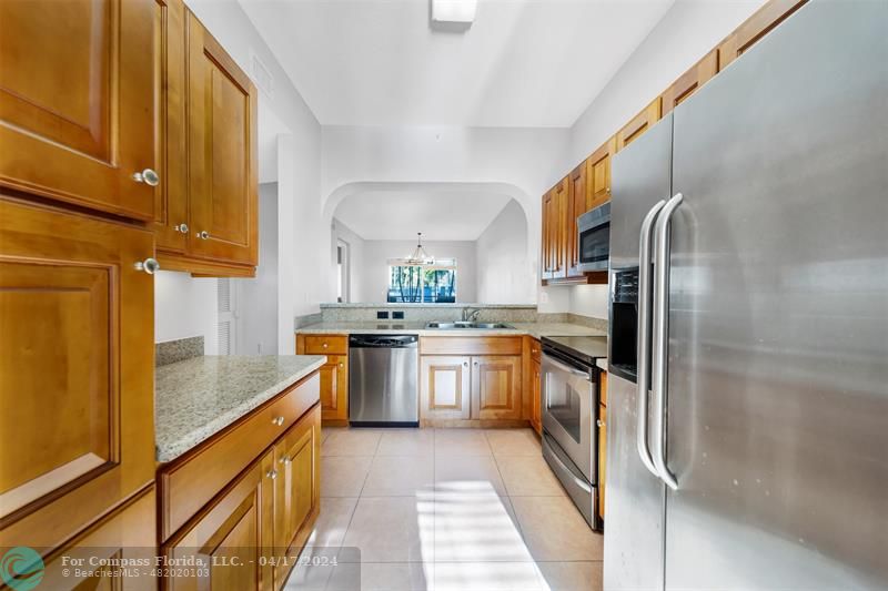 a kitchen with stainless steel appliances granite countertop a sink and refrigerator
