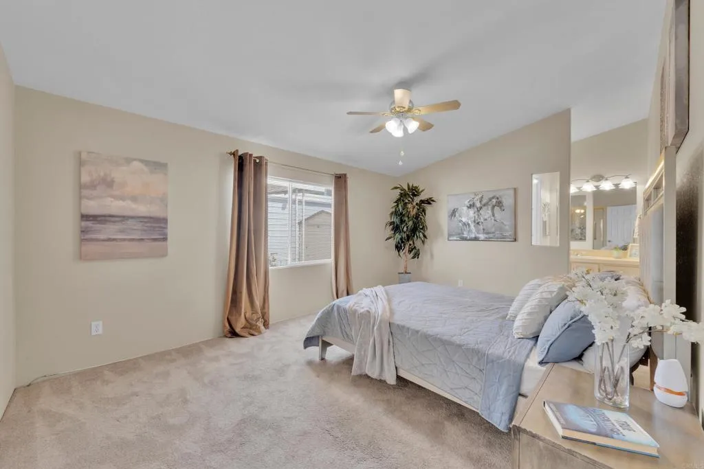 1815 Sweetwater Road, Unit 169 Spring Valley, CA 91977 - Photo 23 of 50 a spacious bedroom with a bed and a chandelier