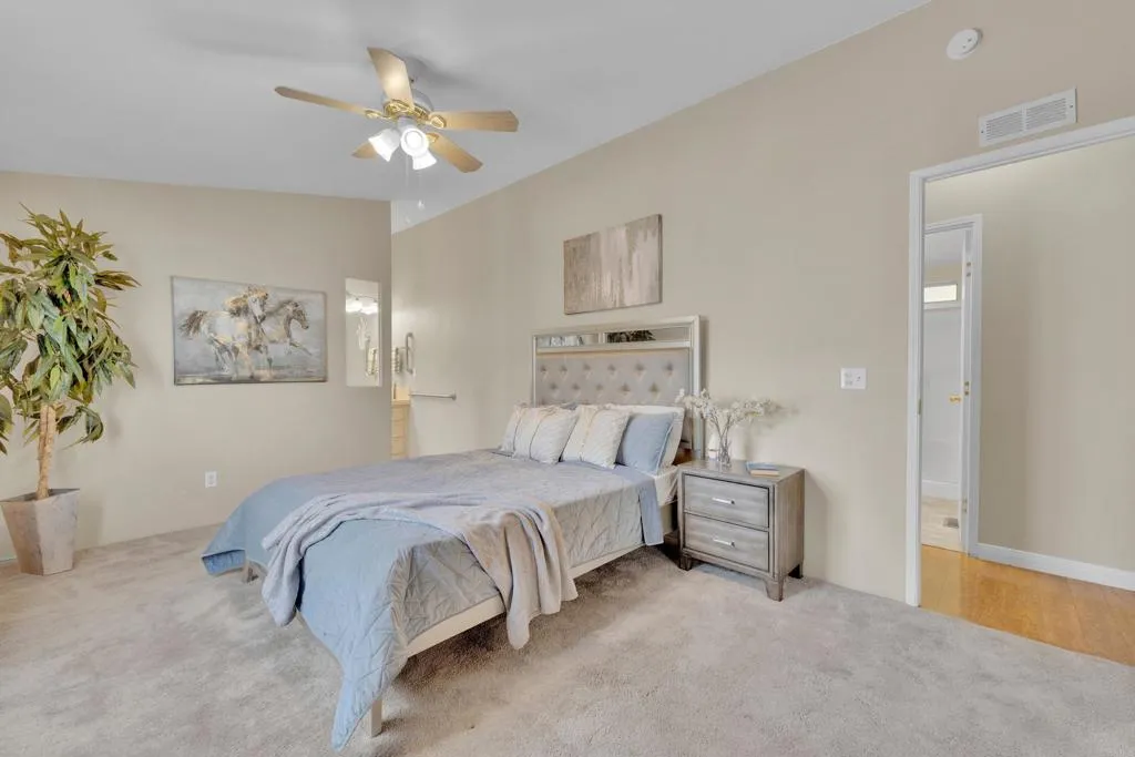 1815 Sweetwater Road, Unit 169 Spring Valley, CA 91977 - Photo 24 of 50 a spacious bedroom with a bed and a chandelier