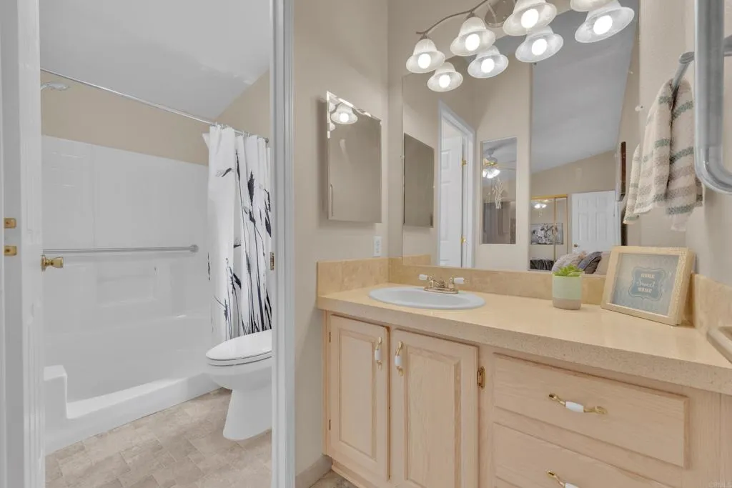 1815 Sweetwater Road, Unit 169 Spring Valley, CA 91977 - Photo 27 of 50 a bathroom with a granite countertop sink a toilet and a mirror