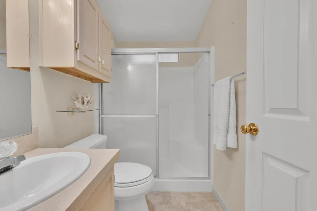 1815 Sweetwater Road, Unit 169 Spring Valley, CA 91977 - Photo 31 of 50 a bathroom with a sink a toilet and shower curtain