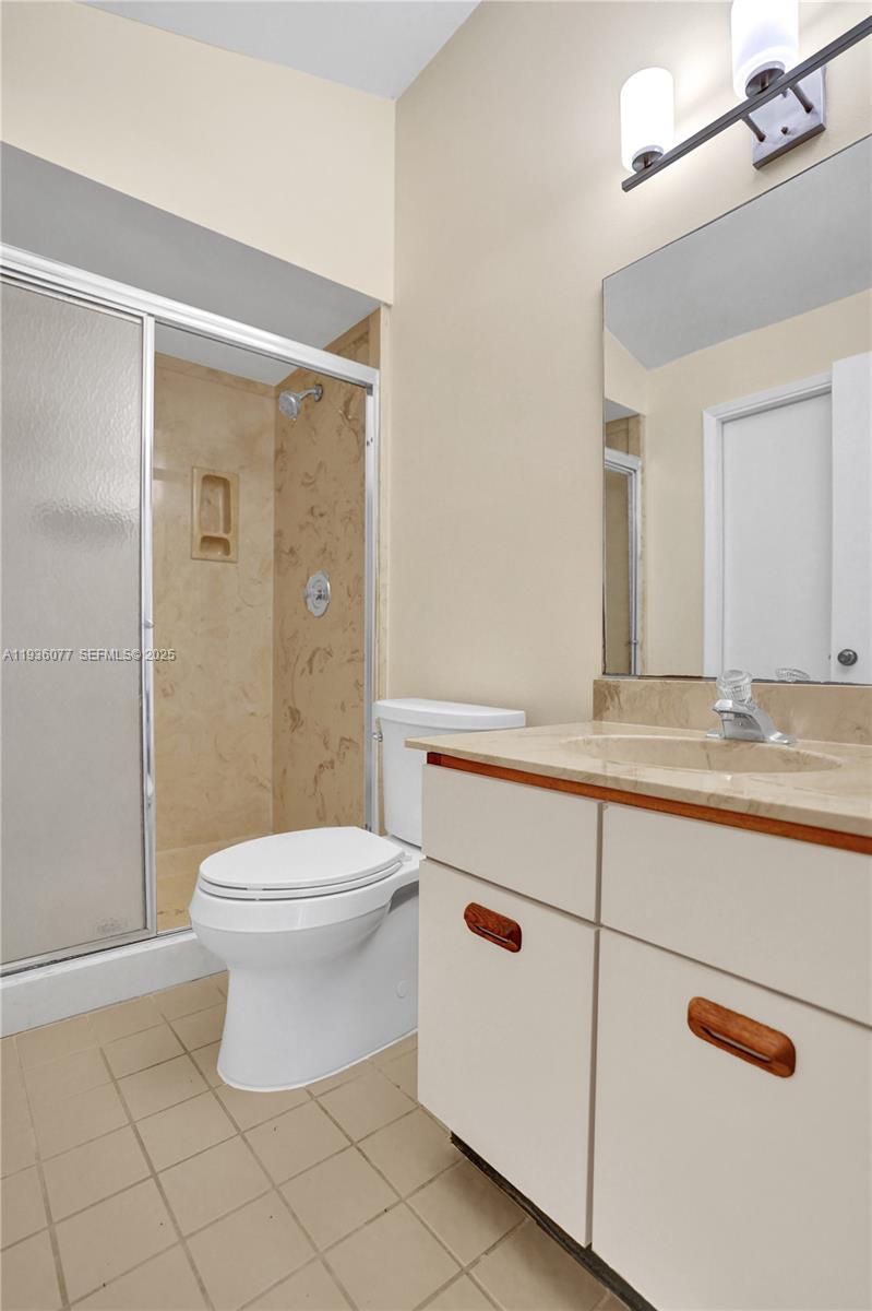 9569 Boca Gardens Parkway, Unit B Boca Raton, FL 33496 - Photo 19 of 40 a bathroom with a toilet a sink and a mirror