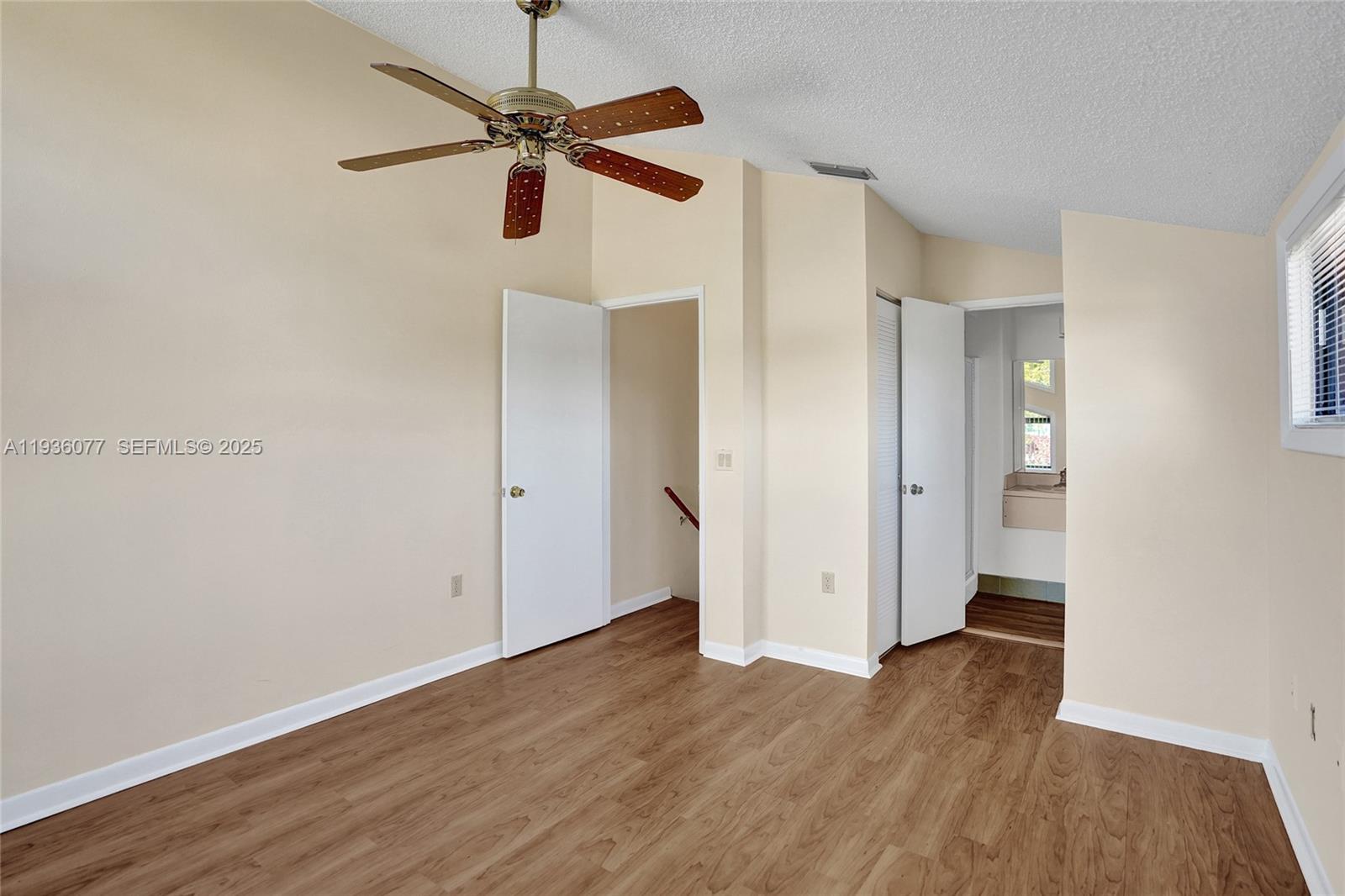 9569 Boca Gardens Parkway, Unit B Boca Raton, FL 33496 - Photo 25 of 40 an empty room with wooden floor a ceiling fan and windows