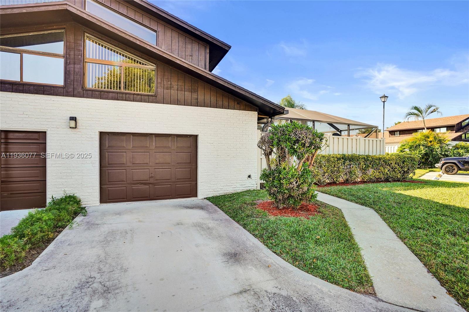 9569 Boca Gardens Parkway, Unit B Boca Raton, FL 33496 - Photo 38 of 40 a front view of a house with a yard and garage