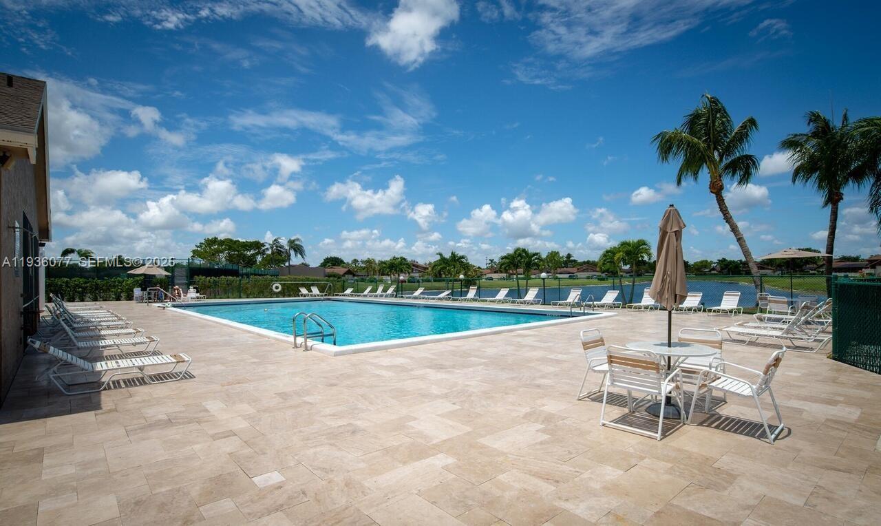 9569 Boca Gardens Parkway, Unit B Boca Raton, FL 33496 - Photo 5 of 40 a view of swimming pool with table and chairs