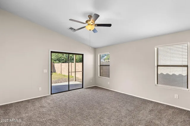 an empty room with a window and a fan