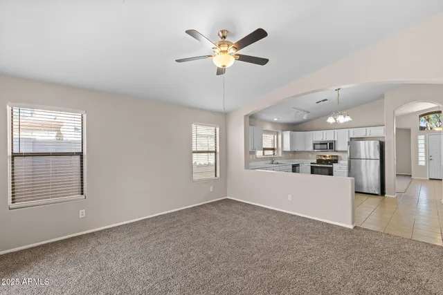 a view of an empty room with window and cabinet