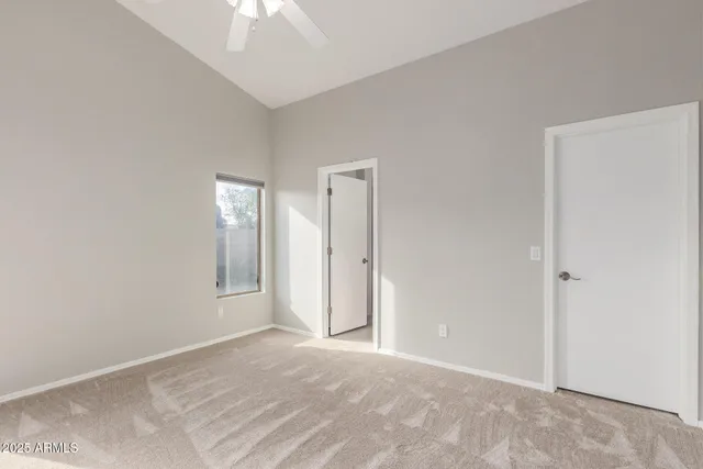 a view of an empty room with a chandelier fan
