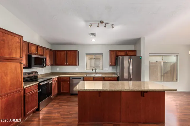 a kitchen with stainless steel appliances a stove microwave and sink