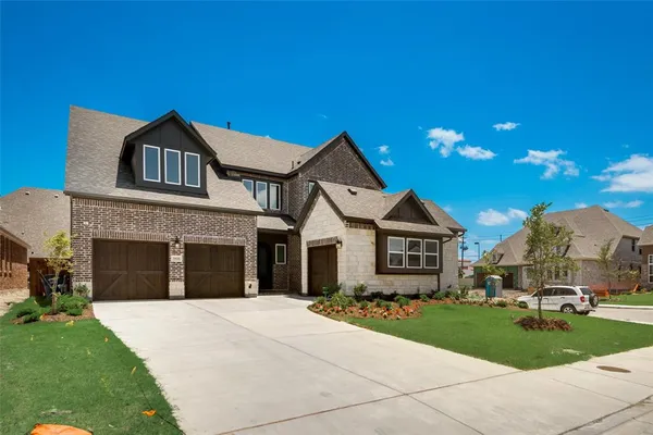 a front view of a house with a garden and yard