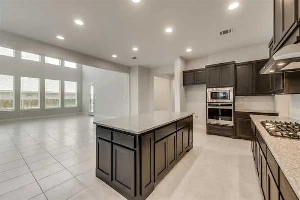 a kitchen with stainless steel appliances granite countertop a stove and a refrigerator