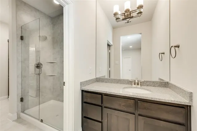 a bathroom with a shower sink vanity and mirror