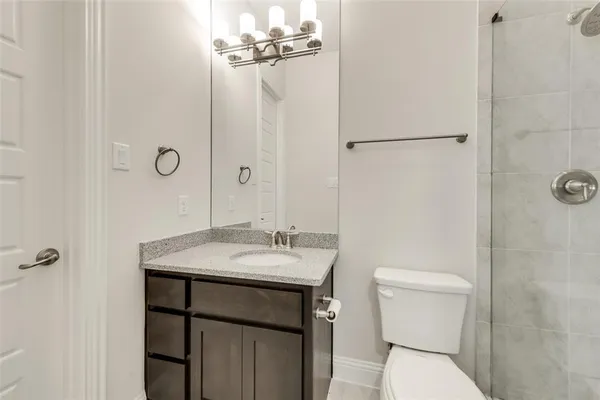 a bathroom with a granite countertop sink toilet and shower