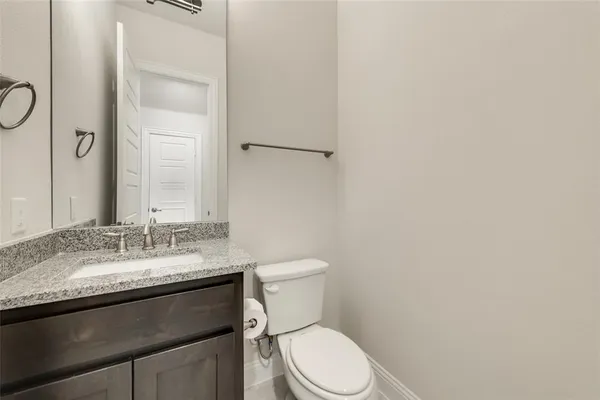 a bathroom with a granite countertop toilet sink and mirror